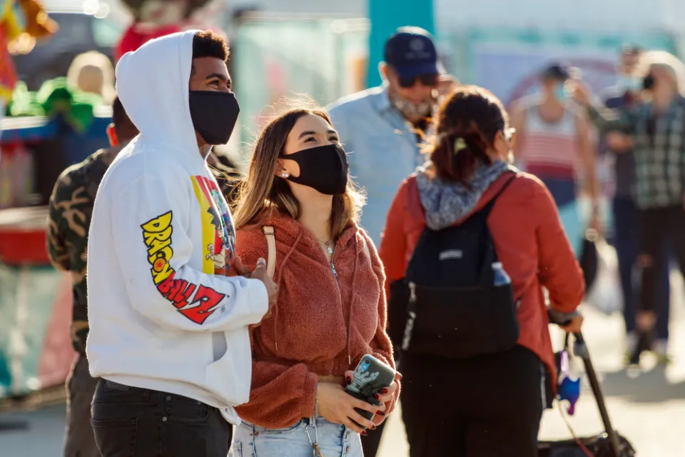 Two young people wear masks while standing outside in Florida.